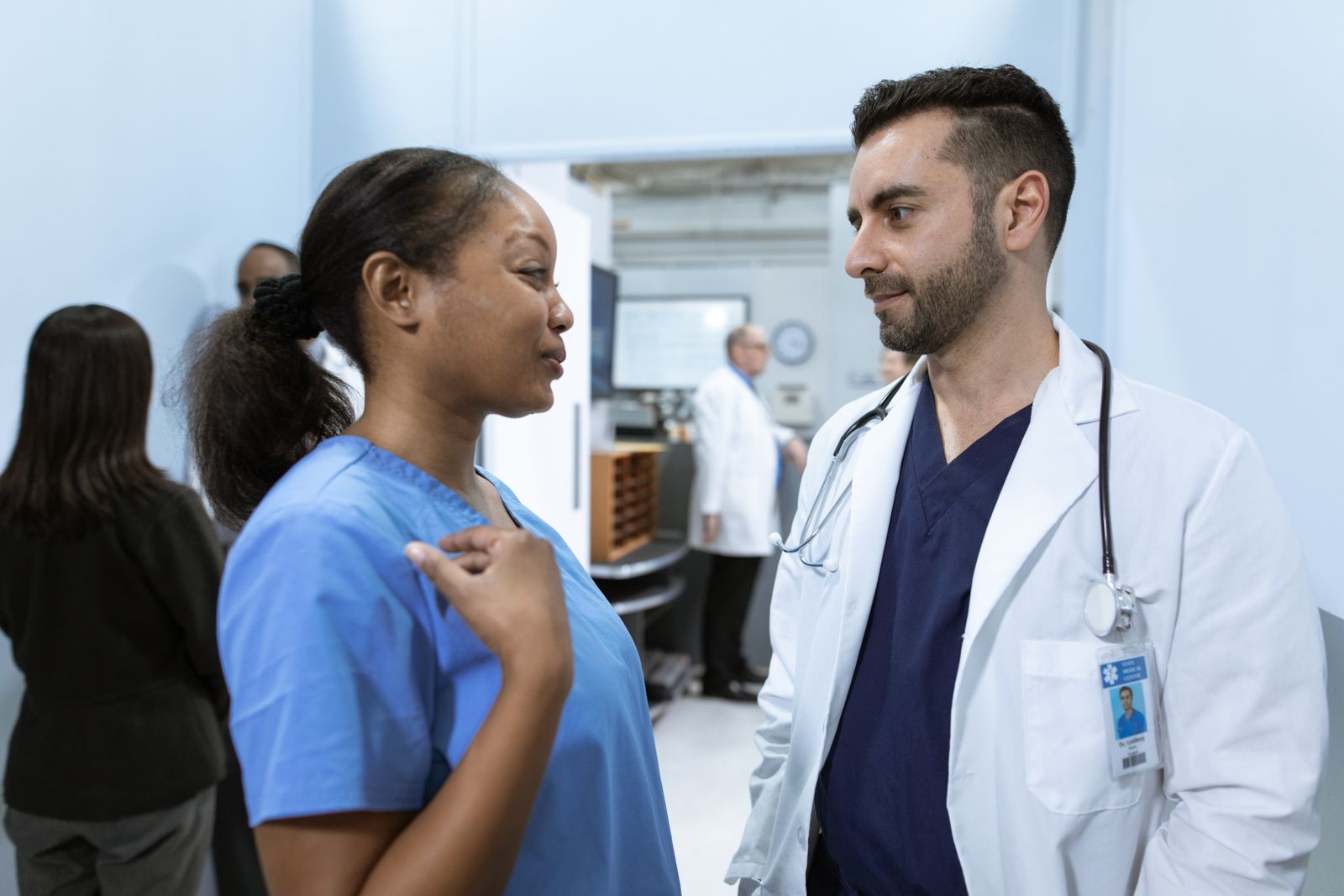 A clinician and a nurse talking in a hospital corridor